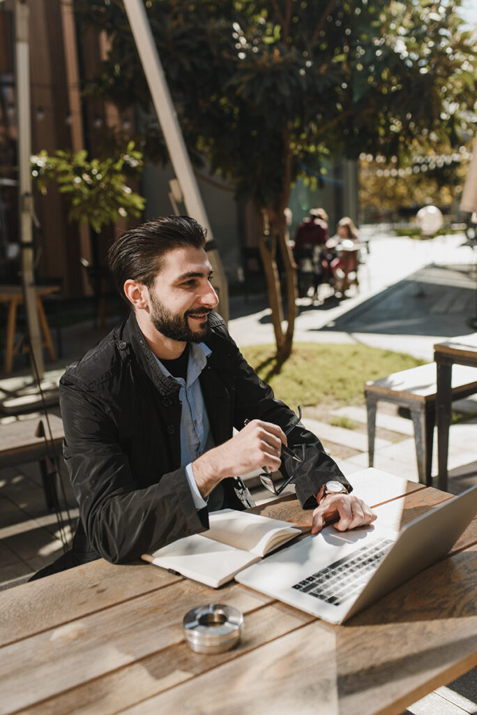 Man enjoying coffee outdoors while studying for his social media manager qualification with Blazebridge Academy